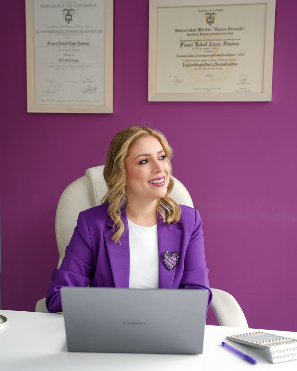 Dra. Francy López en su oficina, con sus diplomas de Odontóloga y Especialista en Implantología Oral y Reconstructiva
